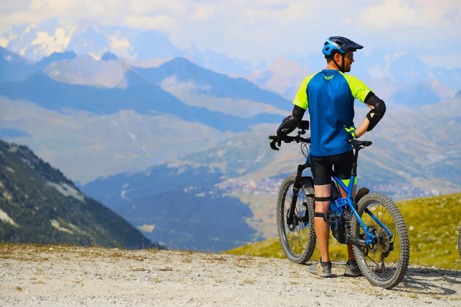 Mountain biker w kasku, ochraniaczach kolan i łokci — akcesoria MTB