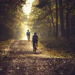 Dwie osoby na rowerach MTB w bukowym lesie o świcie — buty SPD na pedałach