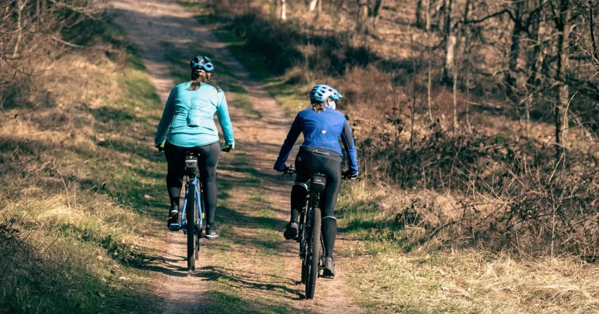 Dwie kobiety na rowerach MTB na leśnej trasie wczesną wiosną