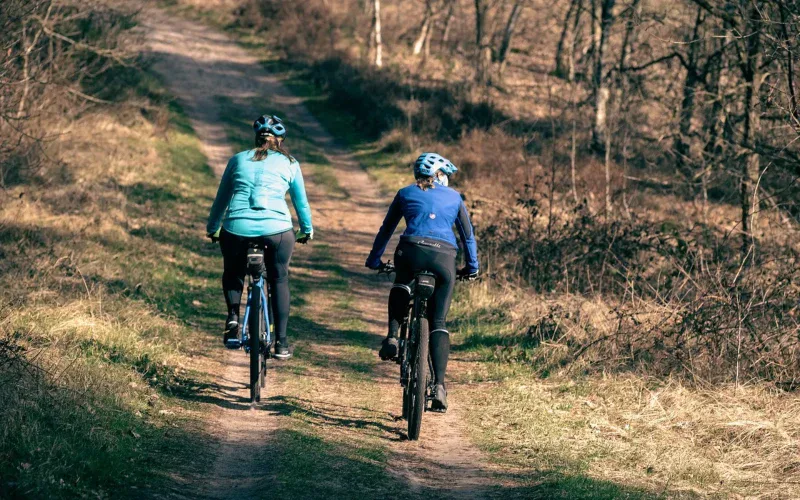 Dwie kobiety na rowerach MTB na leśnej trasie wczesną wiosną