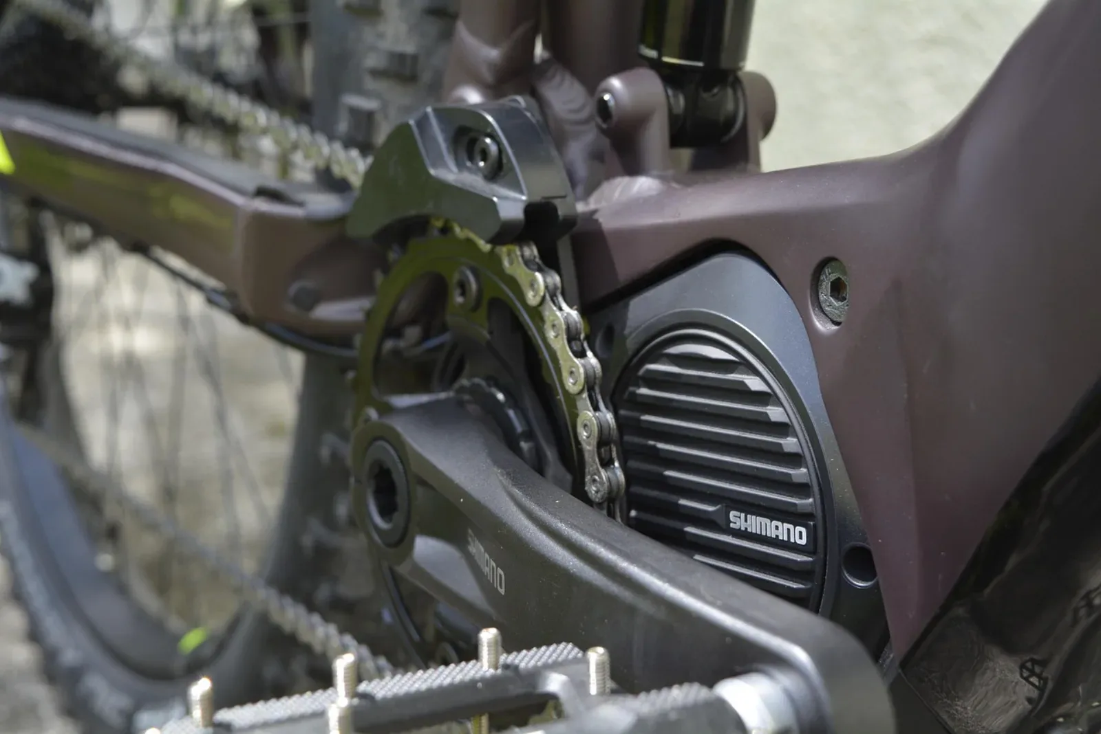Silnik środkowy Shimano e-MTB z mechanizmem korbowym i łańcuchem, close-up ramy roweru pełnozawieszeniowego