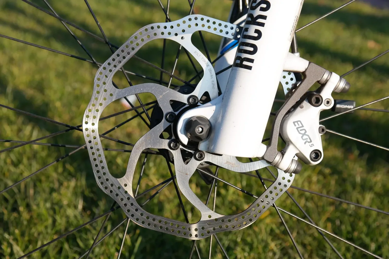 Hamulce rowerowe — tarcza i zacisk hydrauliczny Avid Elixir na białym MTB