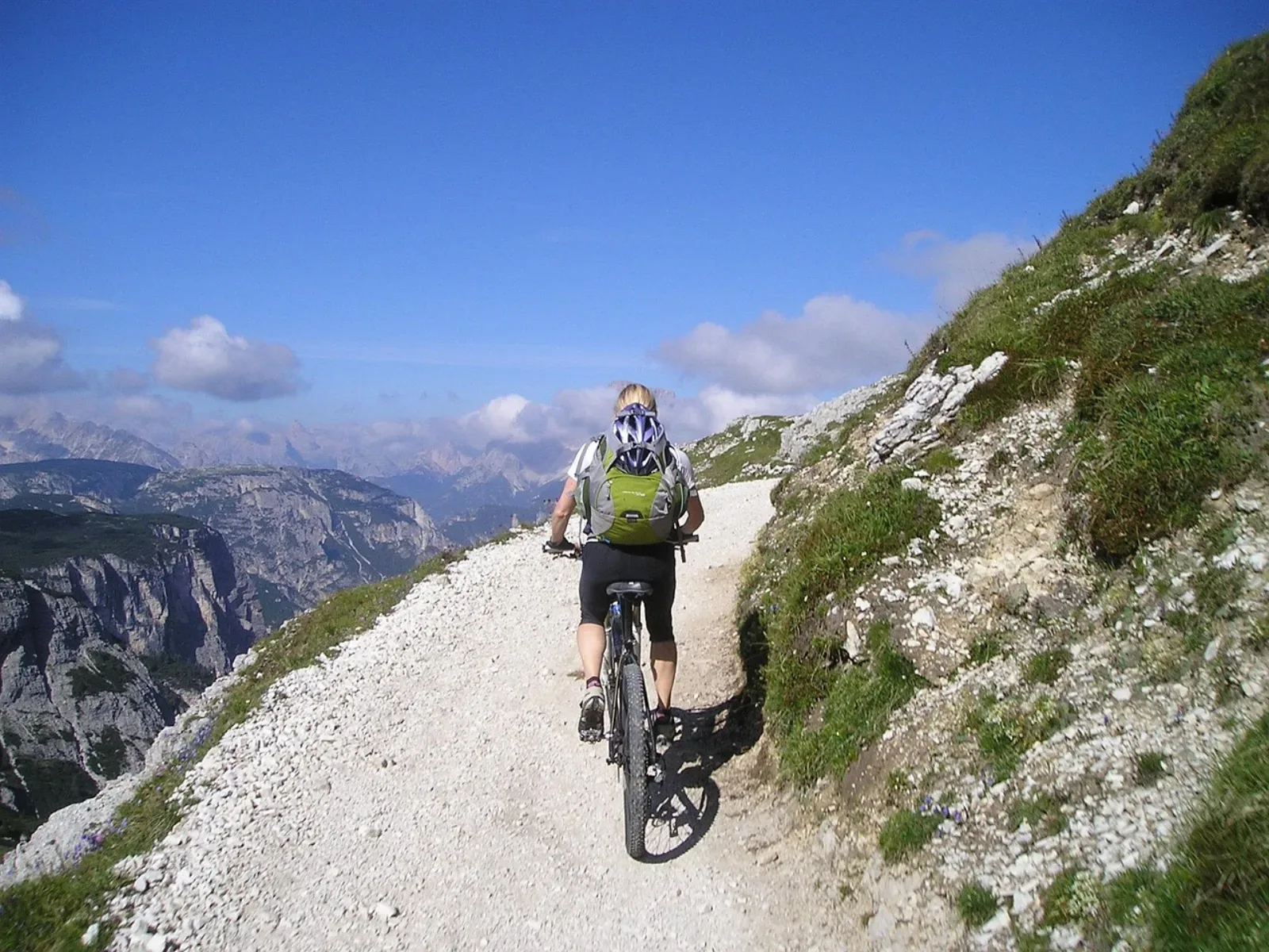 Kobieta na rowerze MTB na alpejskim szlaku w Dolomitach