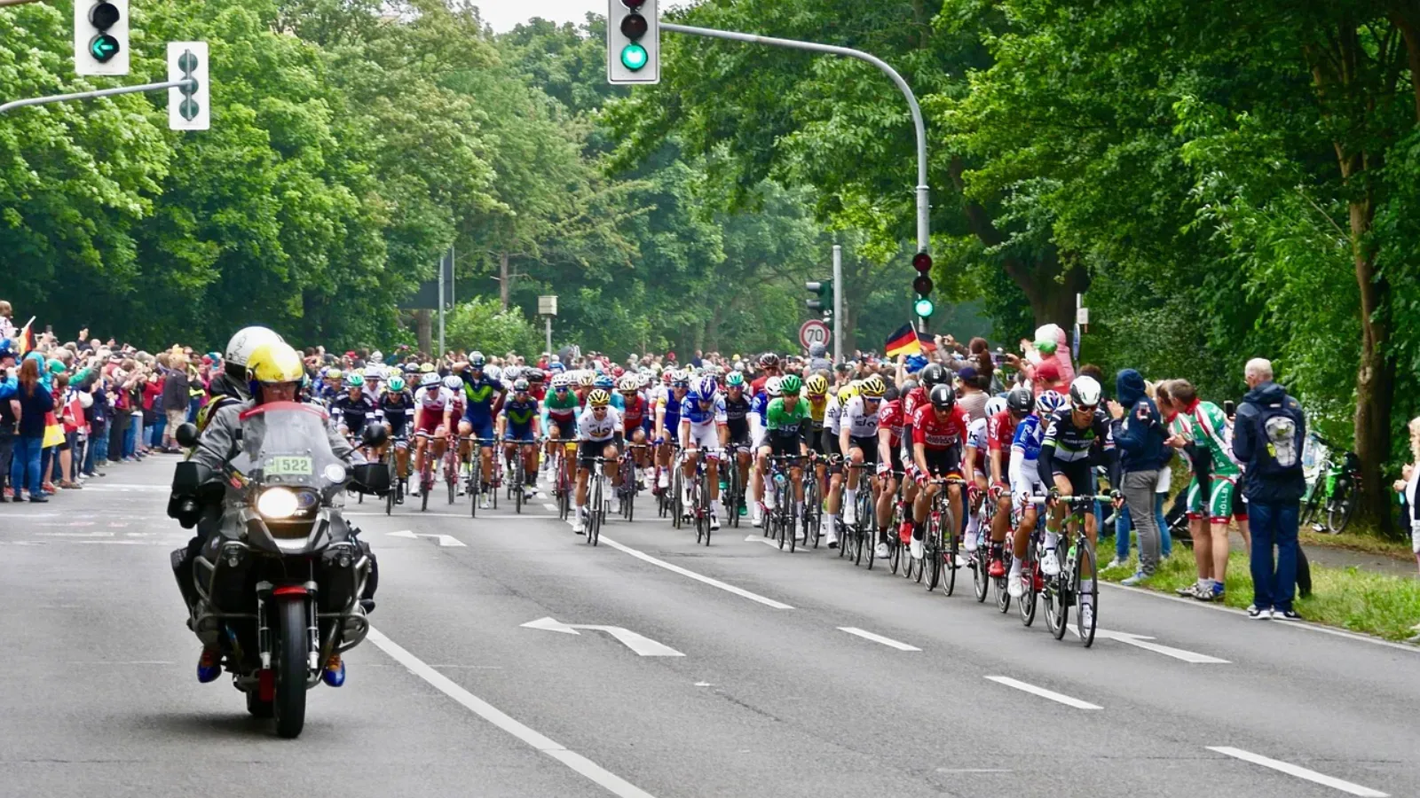 Peloton kolarski podczas wyścigu szosowego z kibicami wzdłuż trasy
