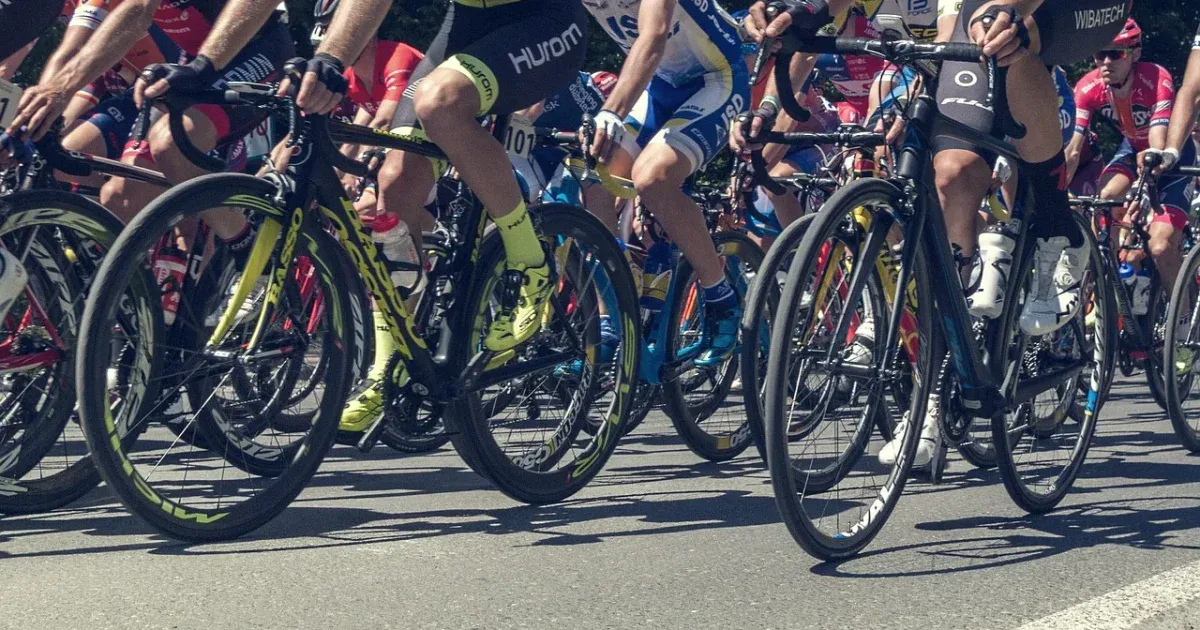 Peleton kolarski w zbliżeniu na koła i nogi zawodników