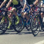 Peleton kolarski w zbliżeniu na koła i nogi zawodników