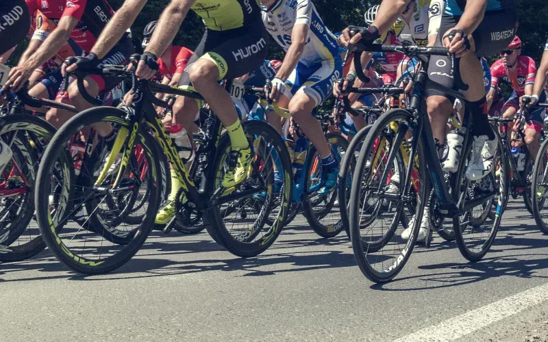 Peleton kolarski w zbliżeniu na koła i nogi zawodników