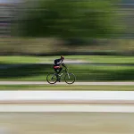 Kolarz szosowy w pełnej prędkości, rozmyte tło w technice panningu