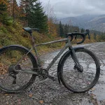 Rower gravel z pełnymi błotnikami na mokrej leśnej drodze jesienią w górach